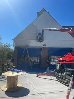 Commercial building white gable exterior painting boom lift