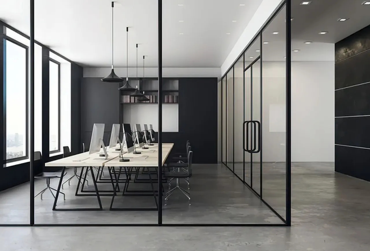 Modern glass-walled conference room with long table, black chairs, and minimalist decor