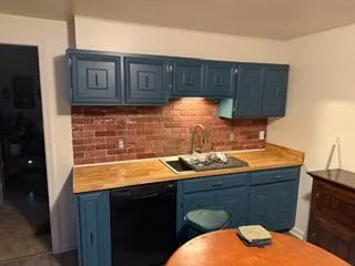 Kitchen cabinets painted blue brick backsplash