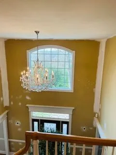 Two story foyer gold walls chandelier before painting