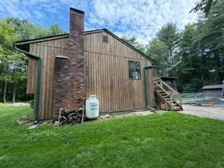 Wood sided house brick chimney before staining